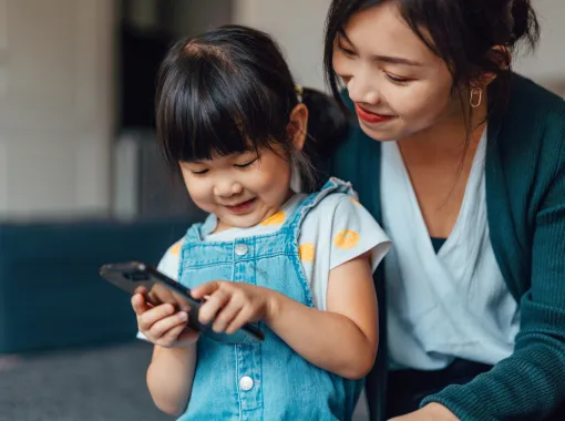Cute toddler and mom using phone